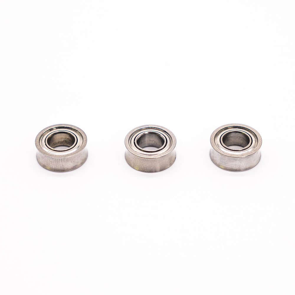 Two yoyo bearings and bearing removal tool on white surface